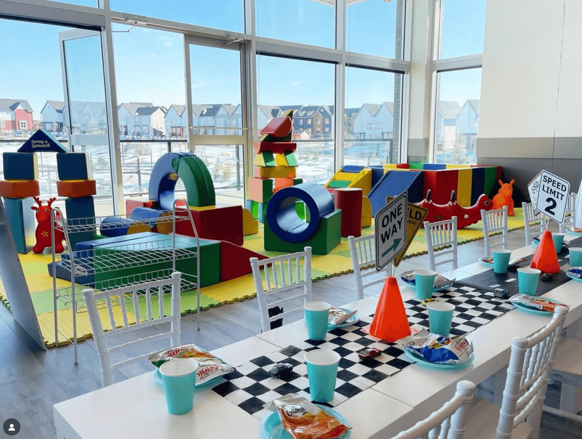 Children's party table setup with playground equipment in a bright, spacious room. Group Activities