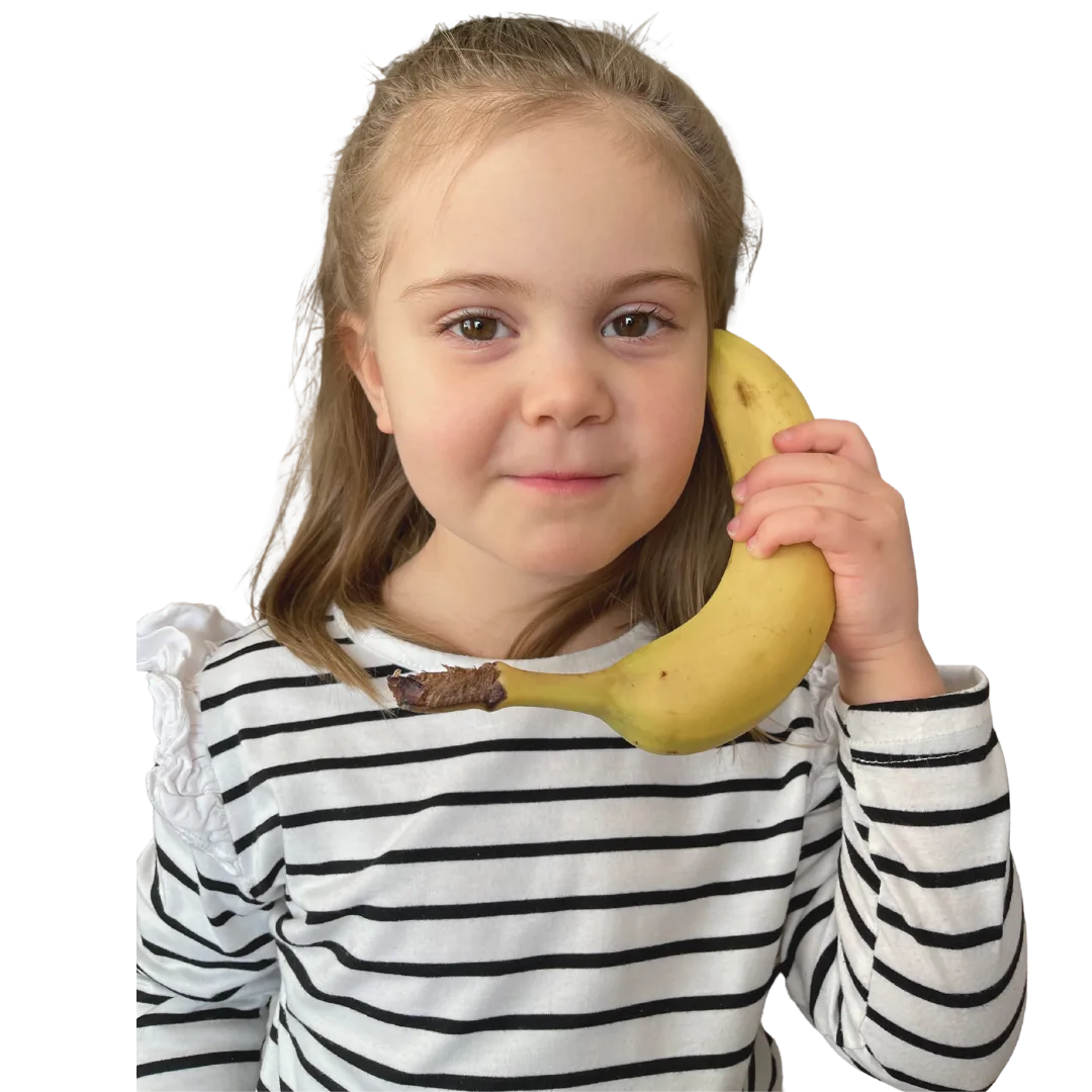 Young girl in striped shirt holding a banana to her ear as a phone.